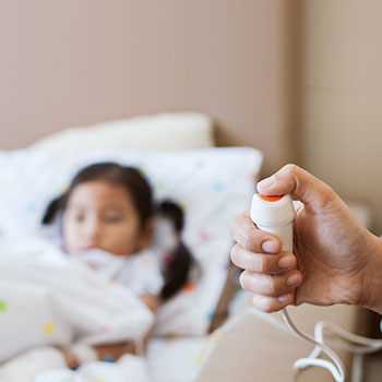 Doctor caring for a young child admitted in a hospital bed, providing attentive inpatient pediatric care