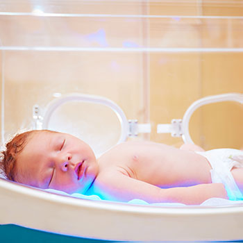 Newborn baby receiving treatment in an incubator for neonatal pneumonia at a hospital neonatal intensive care unit
