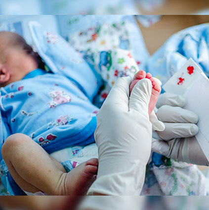 Doctor performing newborn screening blood test on baby’s heel to detect metabolic and genetic disorders