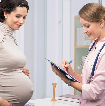 Pregnant woman consulting female gynecologist during preconception counseling session for healthy pregnancy planning